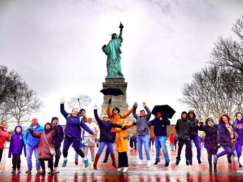 Families posing in front of the Statue of Liberty on Liberty Island