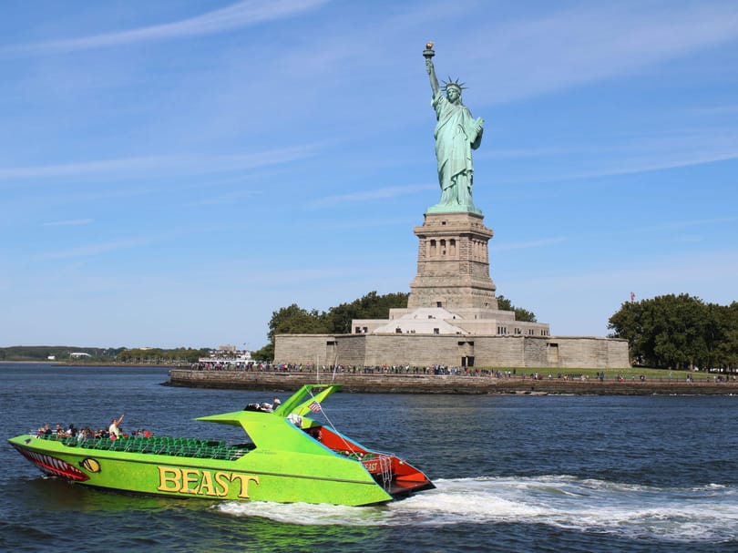 Sightseeing boat passing the Statue of Liberty in New York Harbor