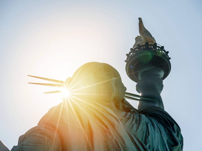 Statue of liberty sun shining from behind