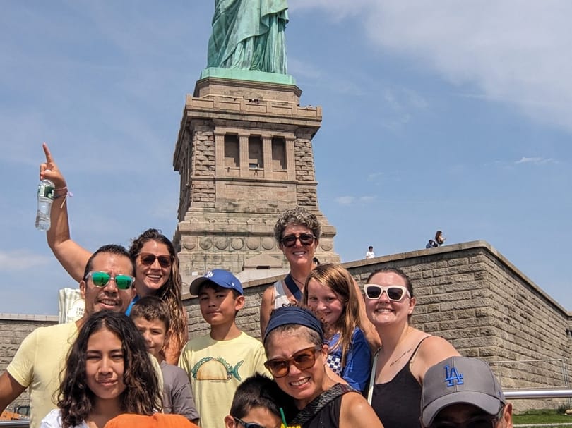 Tour group posing in front of the Statue of Liberty on Liberty Island