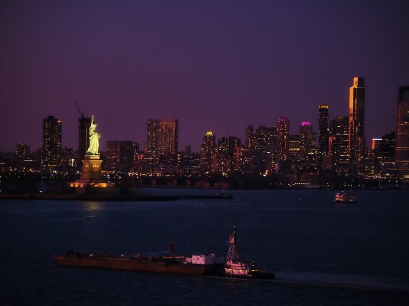 Statue of Liberty with the city in the background at night