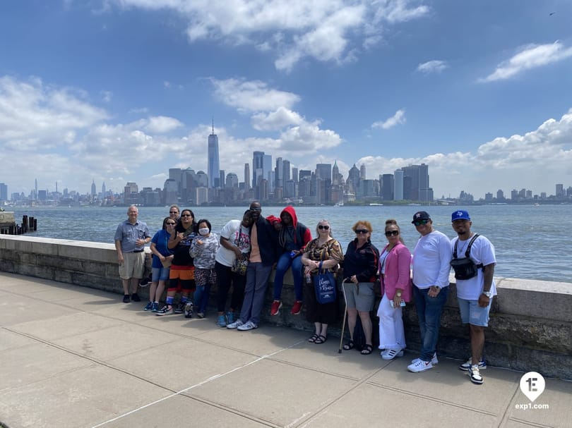 Tour group posing with the Manhattan skyline from Ellis Island