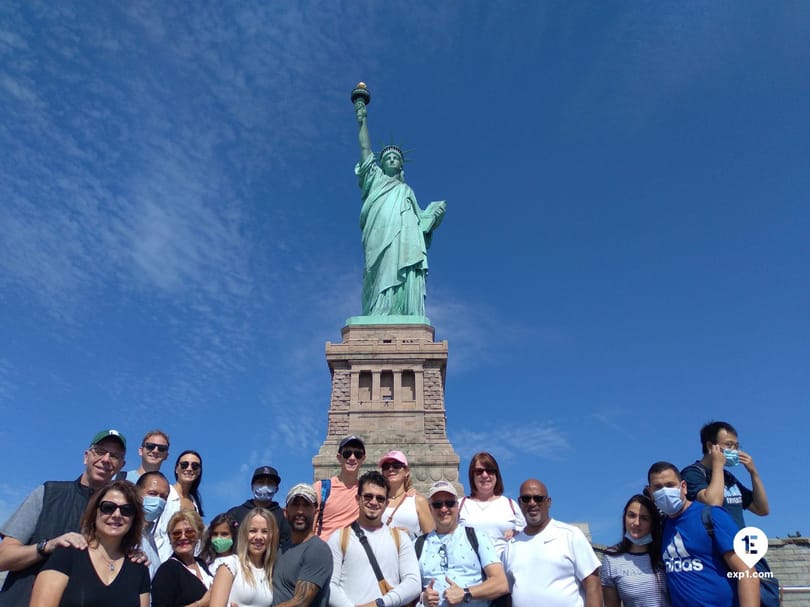 Tour group posing in front of the Statue of Liberty on Liberty Island