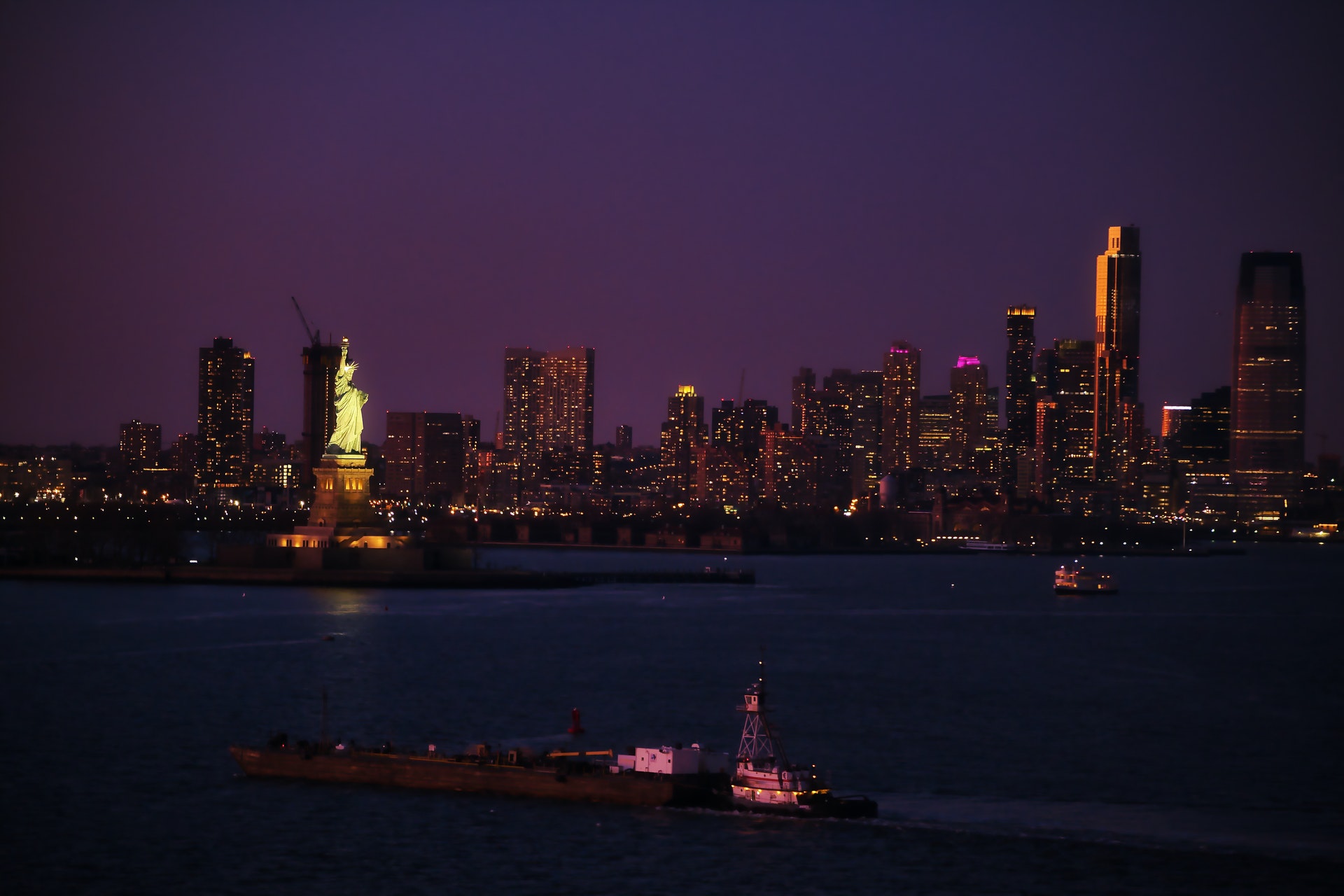 Statue of Liberty with the city in the background at night