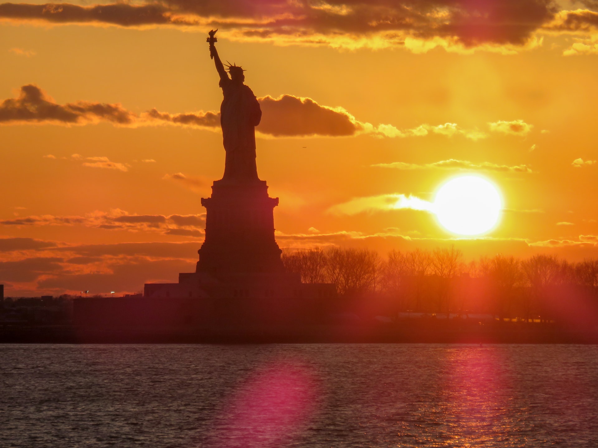 Statue of Liberty on water at sunset