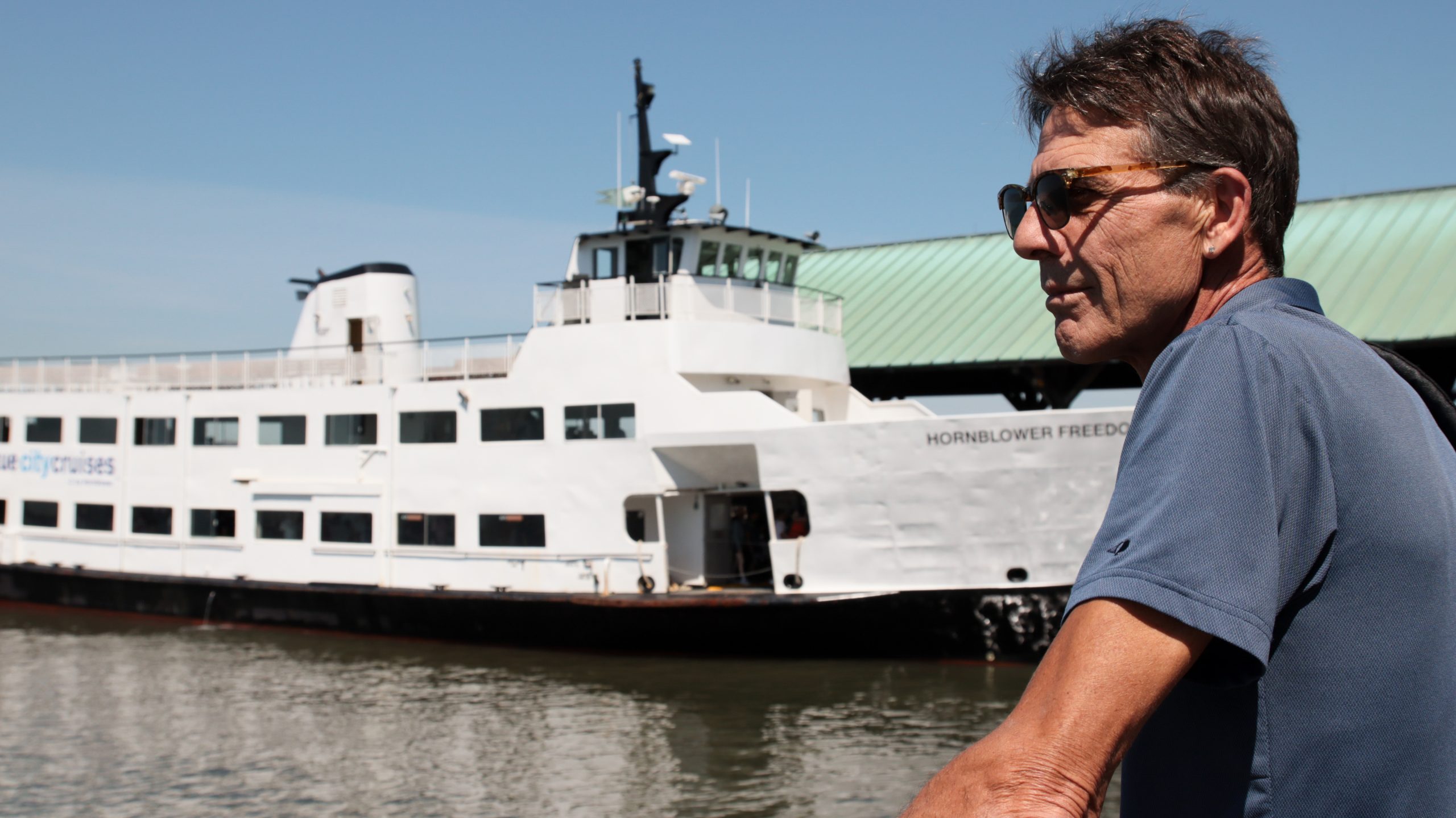 Man and Statue of Liberty cruise boat during Statue of Liberty and Ellis Island tour