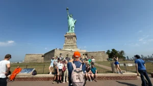 Tour guide taking a group photo at the Statue of Liberty monument