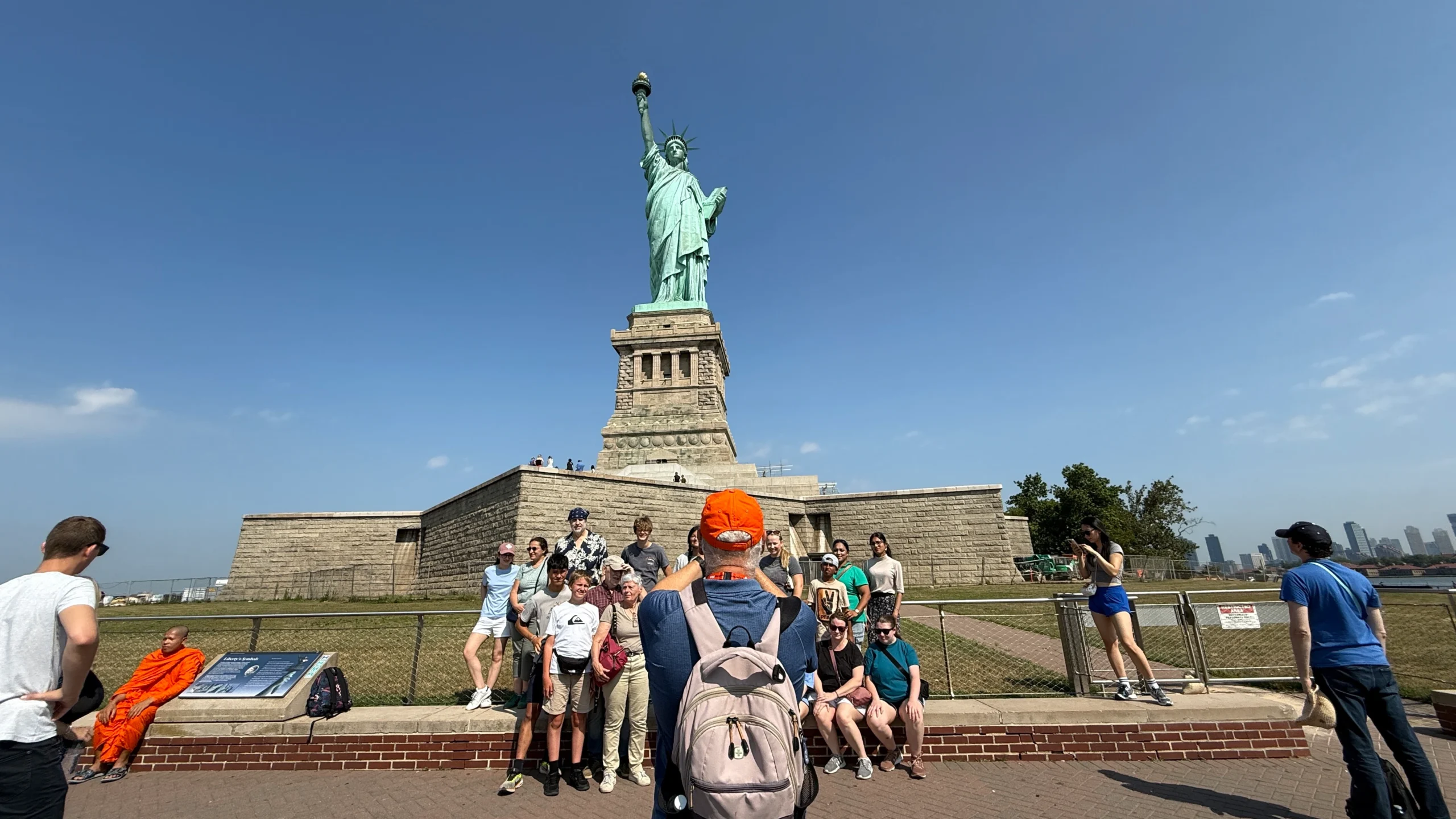 Tour guide taking a group photo at the Statue of Liberty monument